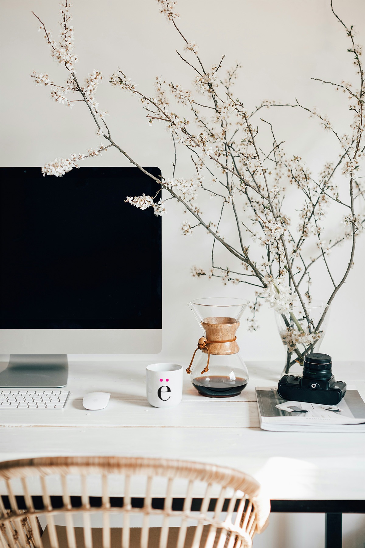 workspace with computer, coffee cup, a plant and a mouse.